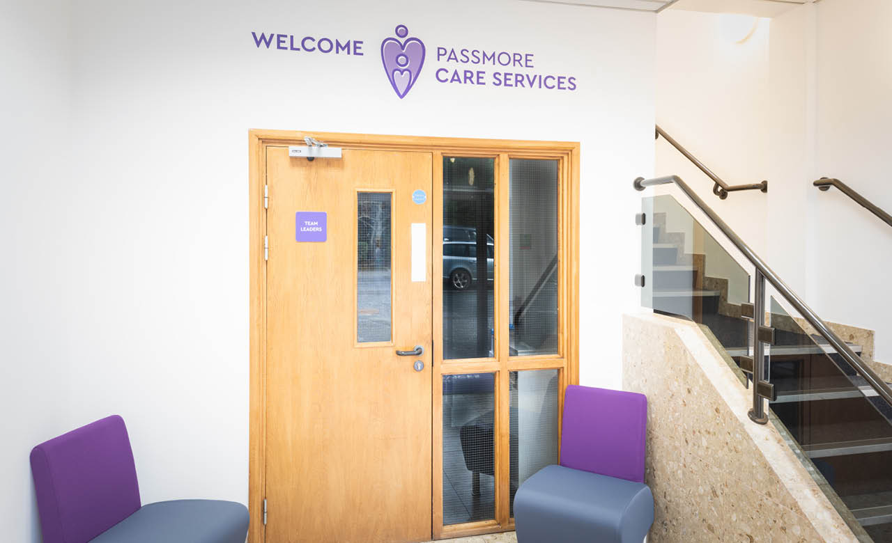 Vinyl application of Passmore's logo on a white wall at their office in Exeter. A great example of simple but effective internal signage.