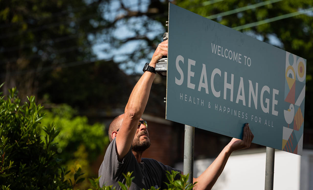 Screwing the exterior signage into position safely.