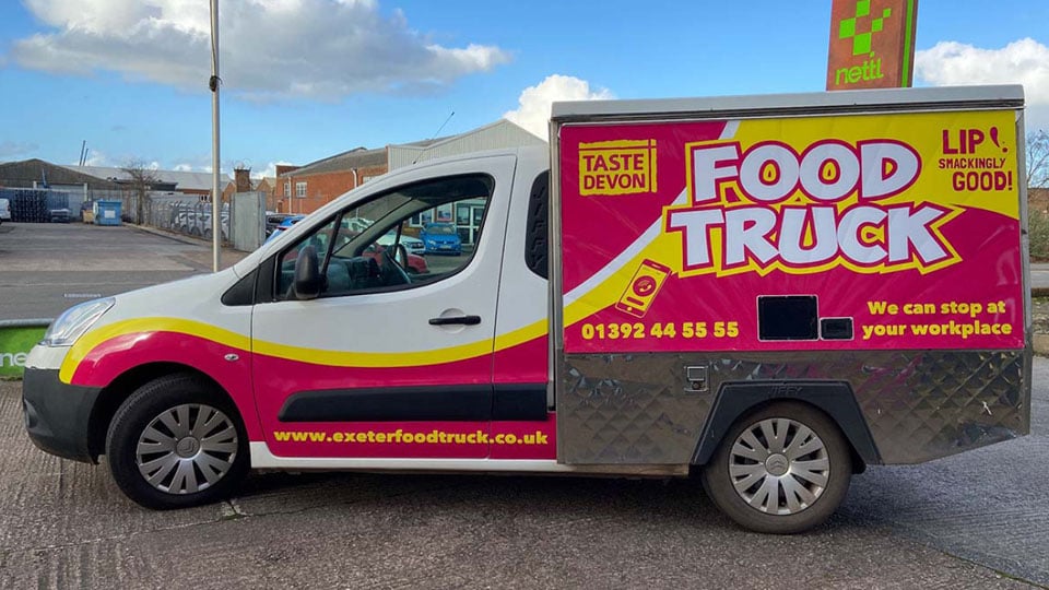 The Taste Devon food truck has a brand new wrap on the side of the vehicle. The van is parked outside the Nettl store.
