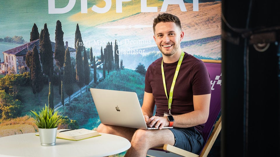 Tom using his laptop to respond to client enquiries and working on digital marketing projects at Nettl of Exeter