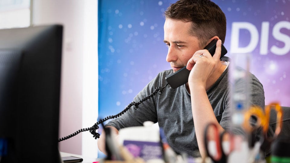 Martin taking phone calls and dealing with signage and vehicle wrapping enquiries at Nettl of Exeter.