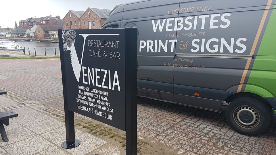 Installation of business signage for Venezia with the Nettl of Exeter van in the background.