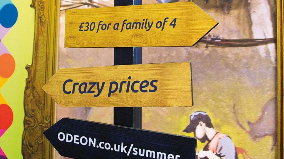 A 3D wayfinding sign with small wooden slats pointing in different directions to help visitors and direct them around the bulding.